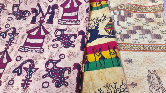 Telas carnaval con diferentes motivos seengales y étnicos (símbolo del cfa, baoba, colores de la bandera de Senegal, máscaras...)